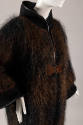 Close up of wool jumpsuit with long, pointed bell sleeves on leather binding
