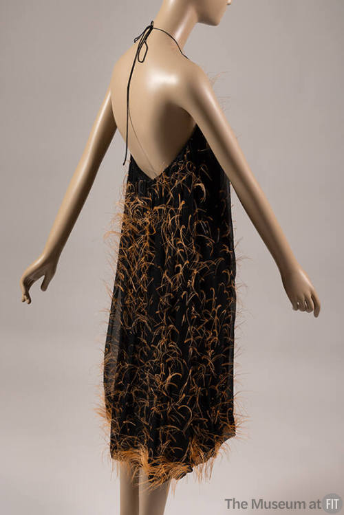 Black underdress with scattered orange feather fringes, backless halter neck