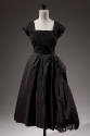 Square neck, black cocktail dress with cap sleeves and flared skirt 

