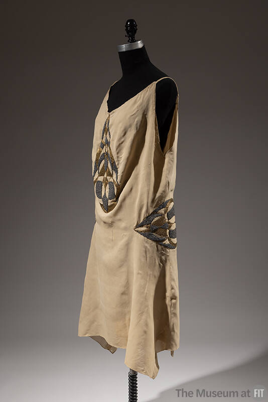 Beige sleeveless silk dress with gold and grey beaded insets at bodice and hips 