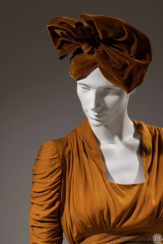 Gold evening dress with matching brown velvet hat