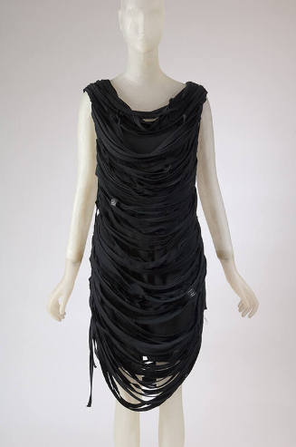 Black sleeveless knee length sheath dress with draped black t-shirt strips overtop