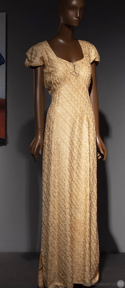 Pale yellow floor-length dress patterned with chain embroidery, squared neck, and short cap sle…
