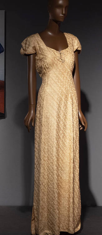 Pale yellow floor-length dress patterned with chain embroidery, squared neck, and short cap sle…