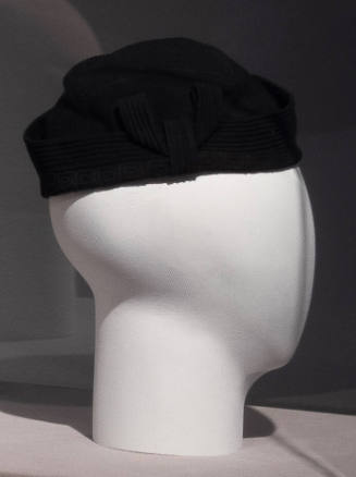 Black brimless hat formed of ribbed and geometric interwoven strips