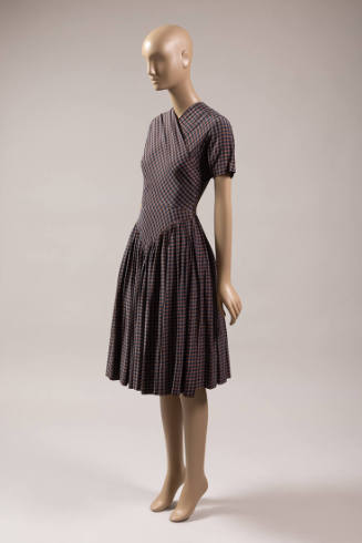Orange/brown, grey, and black check dress with short sleeves and skirt with pointed hip yoke