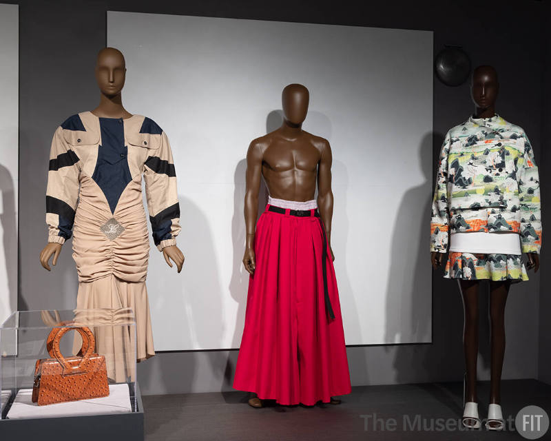 From left to right: Designs by LUAR (2022.79.2 & 2022.79.1), Willy Chavarria (2022.56.2) and Opening Ceremony (2013.54.1) featured in the “Popular Culture '' section of the exhibition ¡Moda Hoy! Latin American and Latinx Fashion Design Today.