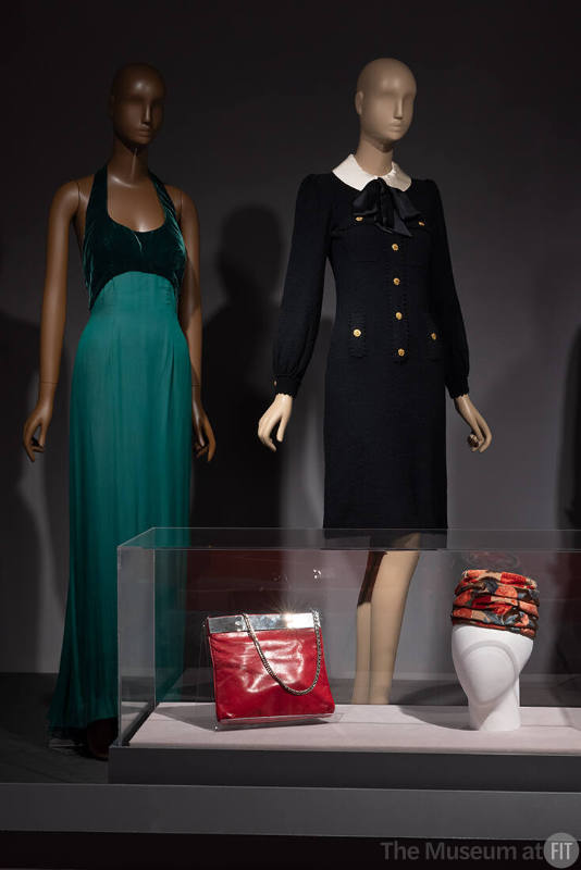 From left to right: Latin American fashion from the mid twentieth century: Estévez green evening gown (78.147.3), Adolfo black knit dress (93.129.10), Carlos Falchi handbag (98.102.5), and Emme pillbox hat (77.190.28) on view in the exhibition ¡Moda Hoy! Latin American and Latinx Fashion Design Today.