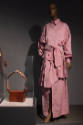 ¡Moda Hoy! exhibition installation view of a brown bag in a case and a mannequin in a pink dres…