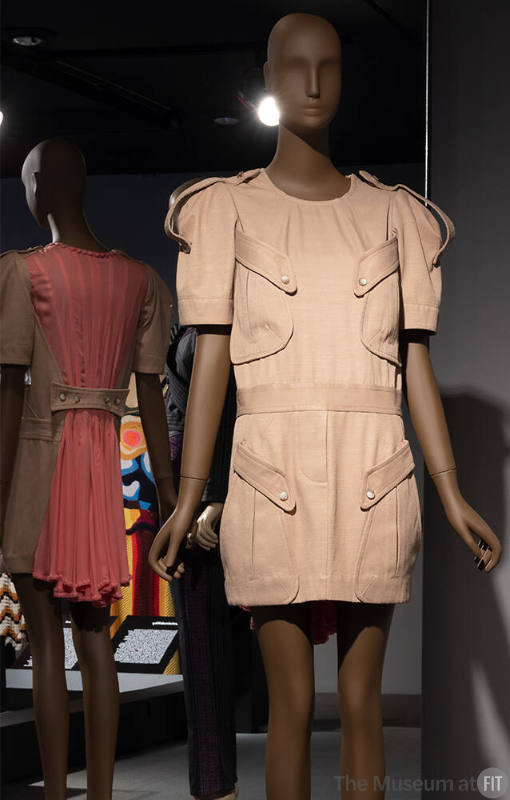 Khaki short sleeve mini dress with shoulder epaulets, oversize pockets at left and right bust a…