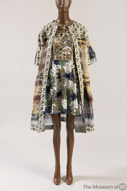 Multicolor print open coat with white paisley print trim over white mini dress with blue, green…