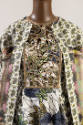 Detail view of printed coat and dress ensemble showing white paisley print trim and upper of co…