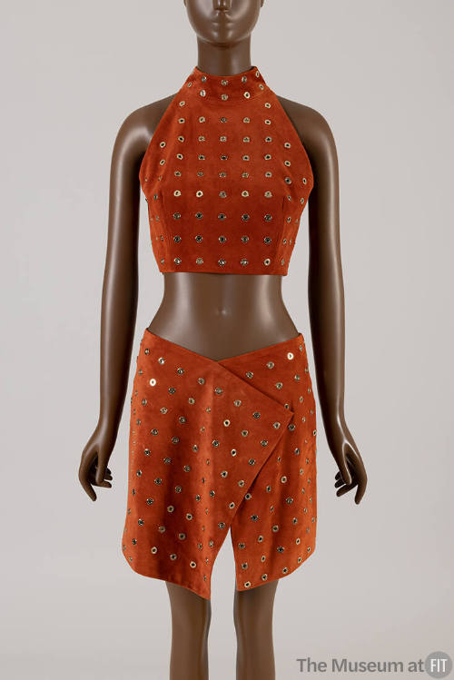 Orange/brown suede matching set of midriff halter top with allover gold grommets and wrap above…