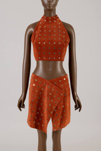 Orange/brown suede matching set of midriff halter top with allover gold grommets and wrap above…
