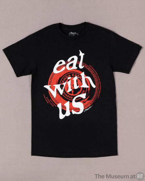 Black short sleeve t-shirt with white text “Eat With Us” superimposed over red Panda Express de…