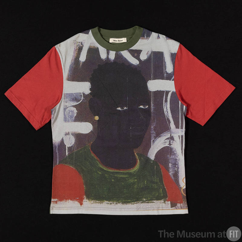T-shirt with green collar, red short sleeves and print of a painted portrait of a man wearing a…