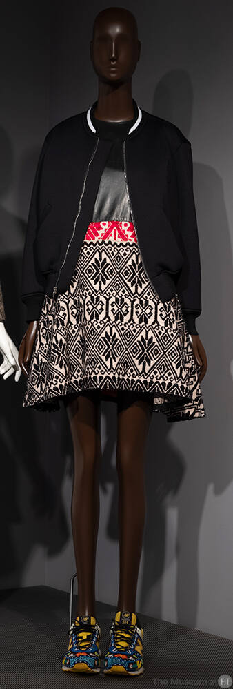 Black bomber jacket over flared mini dress with black bodice and skirt in beige, black and red …