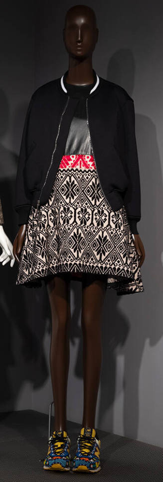 Black bomber jacket over flared mini dress with black bodice and skirt in beige, black and red …
