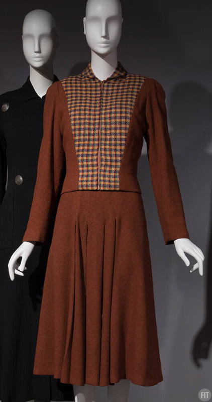 Brown long sleeved jacket with yellow, green, red and brown check front over matching brown dre…