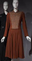Brown long sleeved jacket with yellow, green, red and brown check front over matching brown dre…