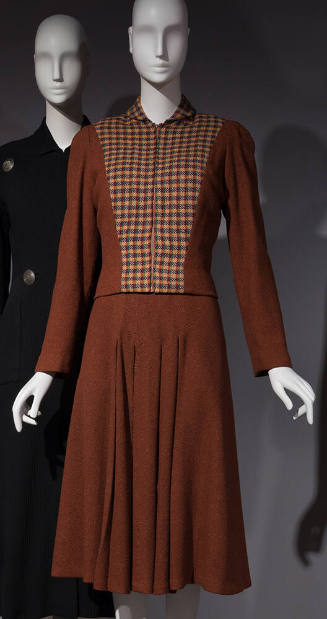 Brown long sleeved jacket with yellow, green, red and brown check front over matching brown dre…