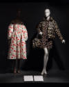 Food & Fashion exhibition installation view of two mannequins in a white cherry print dress and…