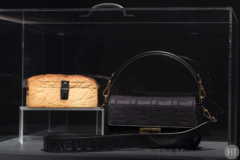 Food & Fashion Left to right: 87.37.1 (bread purse); Fendi, black Baguette bag, Fall/Winter 2023. Lent by Fendi S.r.l.