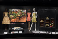 Food & Fashion exhibition installation view three mannequins in dresses, an image of a produce …