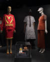 Food & Fashion exhibition installation view of three mannequins in McDonald’s themed ensembles …