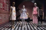 Food & Fashion exhibition installation view of three mannequins in dresses on a black and white…