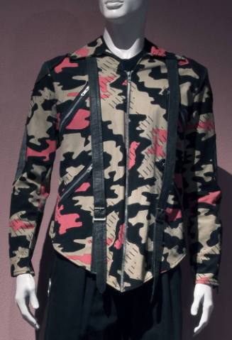 Man’s jacket in beige, pink and black camouflage print with black patches and buckled straps, d…