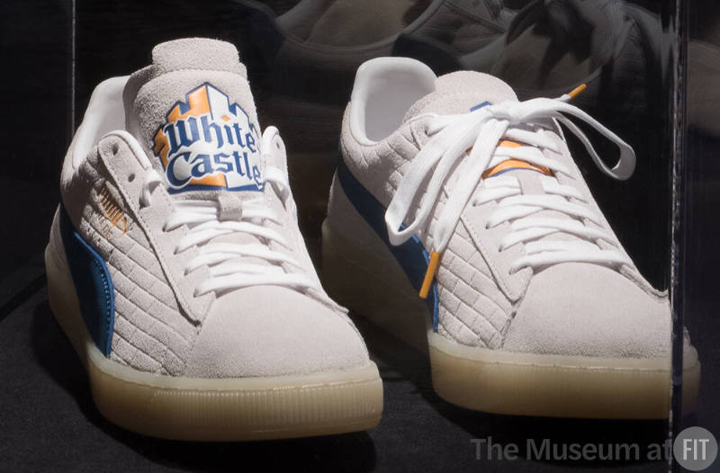 Off-white suede sneakers with white laces and blue, yellow and white White Csstle logo