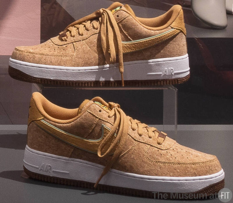Tan cork sneakers with tan laces, swoosh logo and white soles