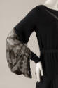 Detail of black dress long sleeve, with lace detail starting from elbow to wrist, draped 