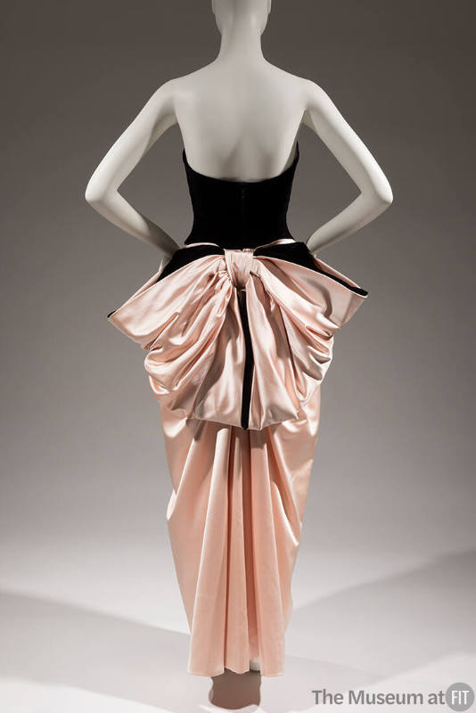 Back view of black strapless floor length gown with large pink satin back bow 