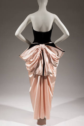 Back view of black strapless floor length gown with large pink satin back bow 