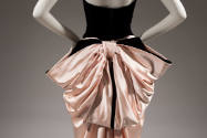 Detail of back of black strapless gown with large pink satin back bow 