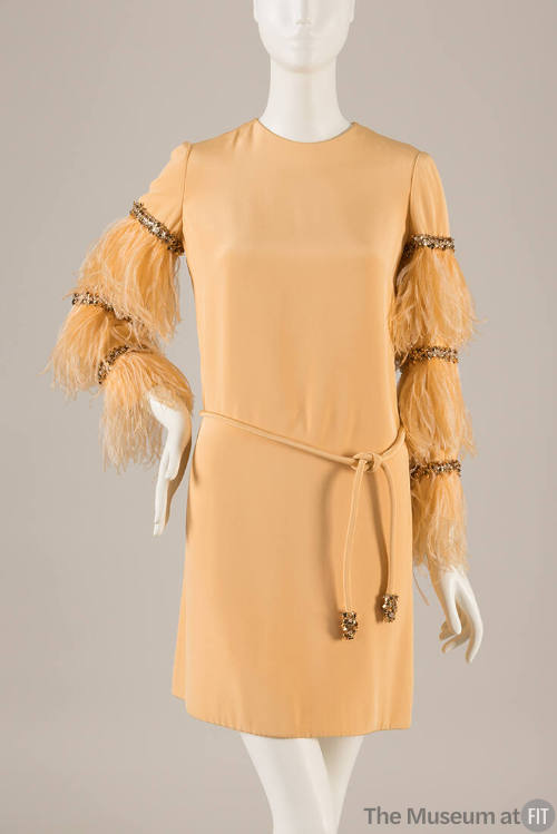 Pale orange mini dress with long feather sleeves with bands of rhinestones and tie belt 