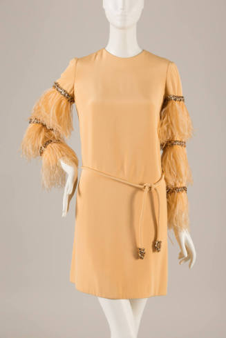 Pale orange mini dress with long feather sleeves with bands of rhinestones and tie belt 