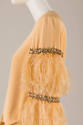 Detail of pale orange dress sleeve with bands of rhinestones and feathers 