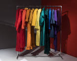 Statement Sleeves exhibition installation view of a rack of clothing in all the colors of the r…