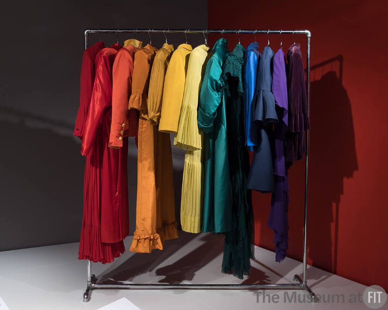 A rainbow of sleeve styles at the entrance to the Statement Sleeves. Left to right: evening dress by Bill Blass, c.1975 (2003.104.1); dress by Norma Kamali, Fall 1985 (2021.61.1); evening suit by Yves Saint Laurent, Fall 1987 (2015.90.18); dress by Batsheva, Fall 2019 (2021.77.8); jacket by Tina Leser, c.1953 (81.200.1); ensemble by Courrèges, c.1961 (76.89.2); dress, c.1925 (81.144.1); evening coat by Christian Dior, c.1955 (71.213.8);  evening dress by Molyneux, c.1929 (P86.66.5), suit by Thierry Mugler, c.1996 (2011.36.1); cocktail dress by Balenciaga, Fall 1968 (85.179.5); evening dress by Valentino, 1971 (2007.5.2); evening jacket, c.1924 (77.225.1)