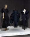 Statement Sleeves exhibition installation view of three mannequins in dark blue and black dress…