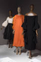 Statement Sleeves exhibition installation view of three mannequins in black and white, orange a…
