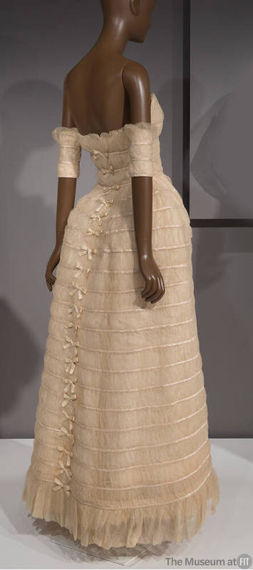Back view of strapless, floor length ivory silk tulle gown with horizontal rows of satin bands …