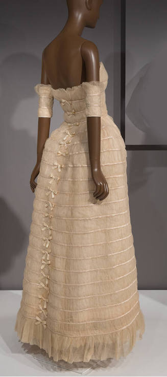 Back view of strapless, floor length ivory silk tulle gown with horizontal rows of satin bands …