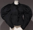 Black top with large puffy sleeves and ruffle down the center front