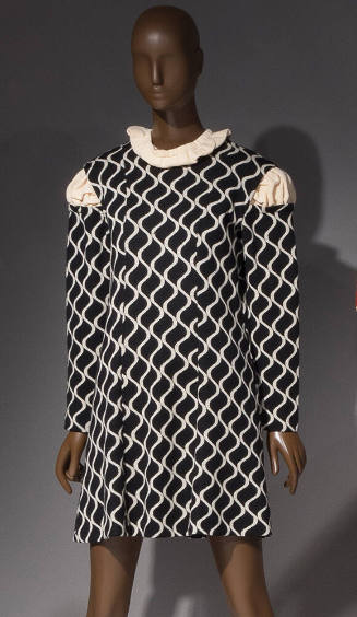 Black shift long sleeved dress with ivory vertical wavy lines, ivory knit inserted at neck and …