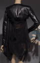Back view of black leather cropped jacket over sheer black dress and skirt with asymmetrical dr…