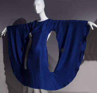 Blue cocktail dress with mannequin arms outstretched to create a semi-circle with long sleeves …